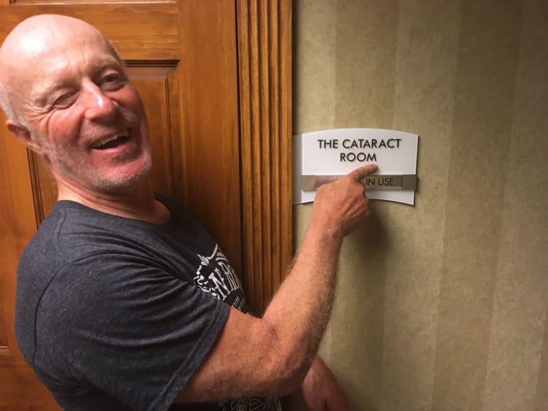 Chris points to the hotel meeting room sign reading "Cataract Room"