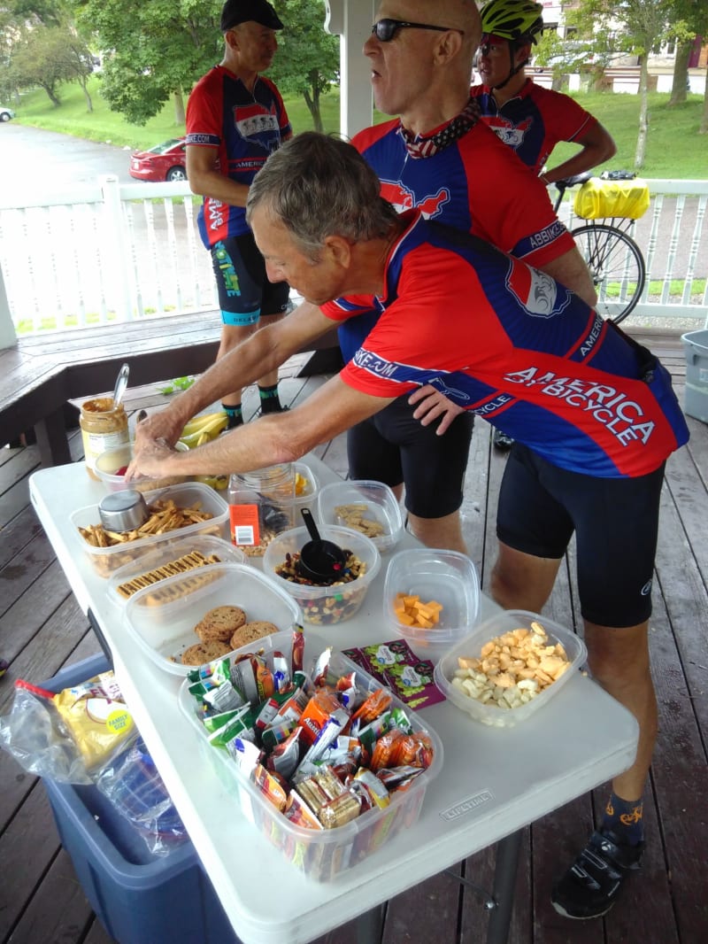 Chris and Judge Ted refuel at a SAG stop. There are cheese curds amongst other sweets and fruit on the table.